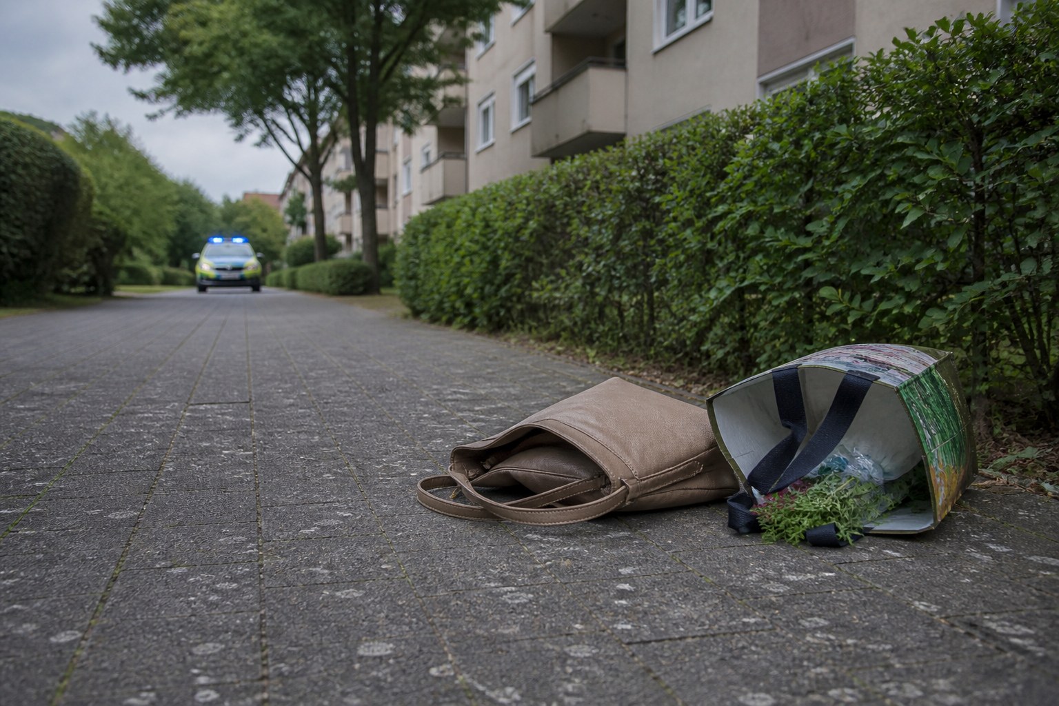 Symbolbild: Eine zurückgelassene Handtasche auf einem Gehweg in einem Hürther Wohngebiet