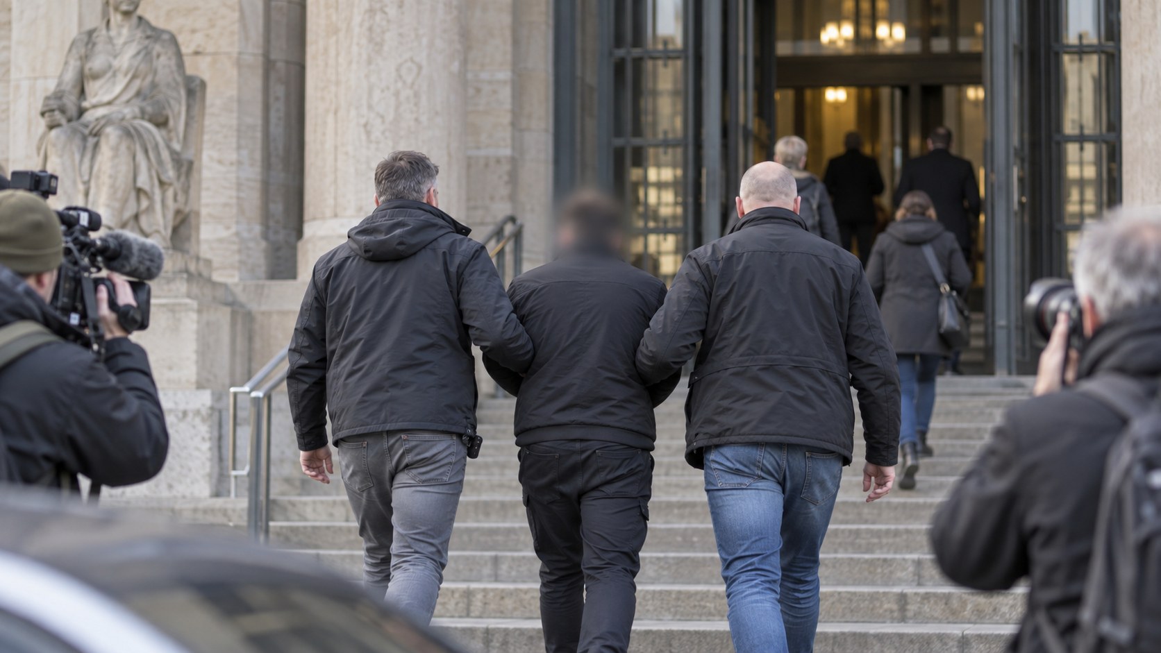 Ankunft eines Angeklagten vor einem Gerichtsgebäude zum Prozess in Köln